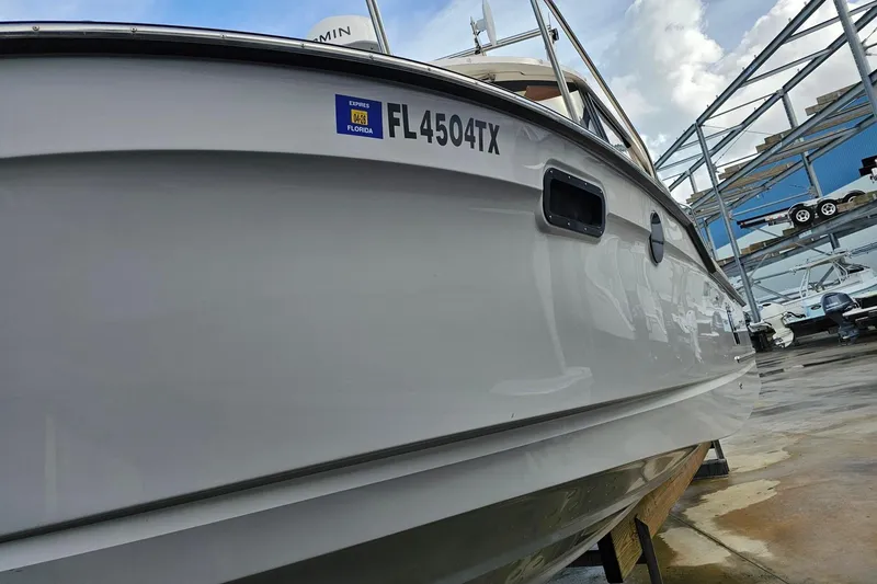 Slide: The Image of 2025 Ranger Tugs R-27 boat docked, displaying Florida registration FL 4504 TX. - 5
