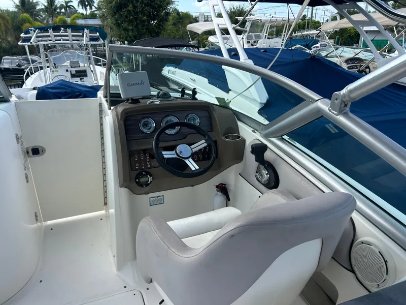 Slide: The Image of 2011 Sea Ray 300 Sundeck boat cockpit with steering wheel and Garmin navigation system. - 11