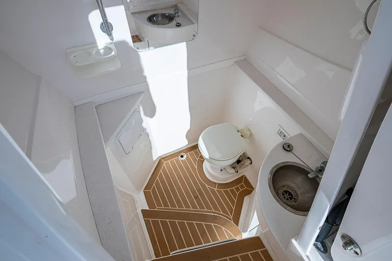 Slide: The Image of 2019 Intrepid 407 Nomad FE boat bathroom with toilet, sink, and wooden floor. - 13