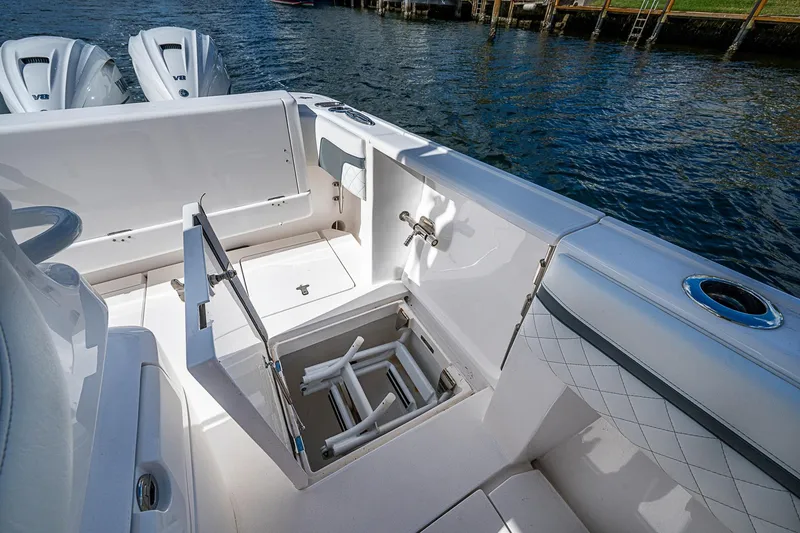 Slide: The Image of 2019 Intrepid 407 Nomad FE boat interior with open storage compartment and twin engines. - 21