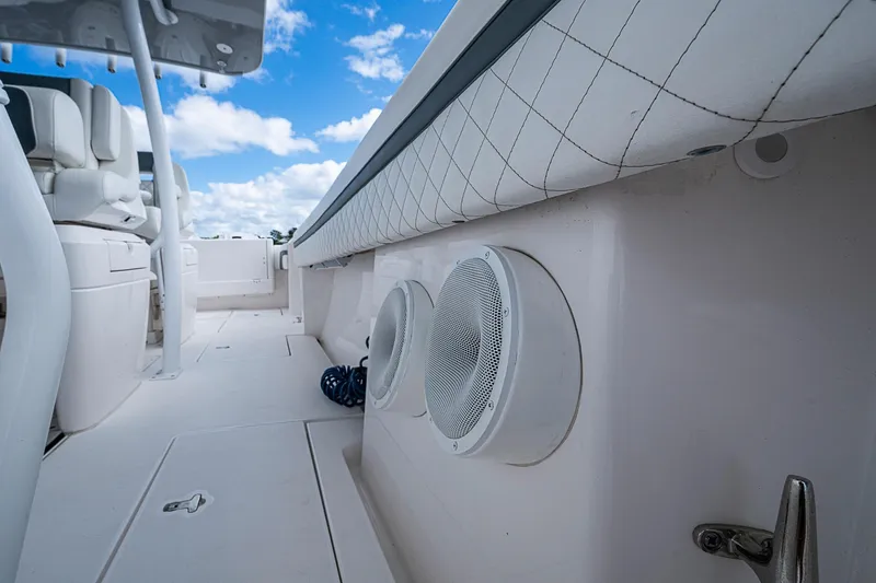 Slide: The Image of 2019 Intrepid 407 Nomad FE boat interior with speakers and seating under blue sky. - 23