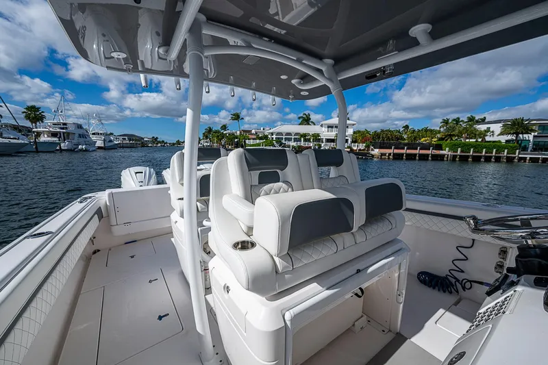 Slide: The Image of 2019 Intrepid 407 Nomad FE boat interior with luxurious seating, docked by waterfront homes. - 31