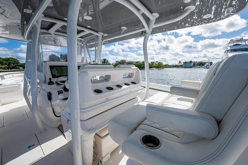 Slide: The Image of 2019 Intrepid 407 Nomad FE boat interior with luxurious seating and helm, overlooking serene waters. - 34