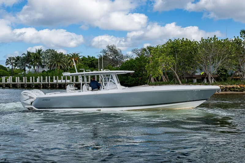 Slide: The Image of 2019 Intrepid 407 Nomad FE boat cruising on a scenic waterway with lush greenery. - 43