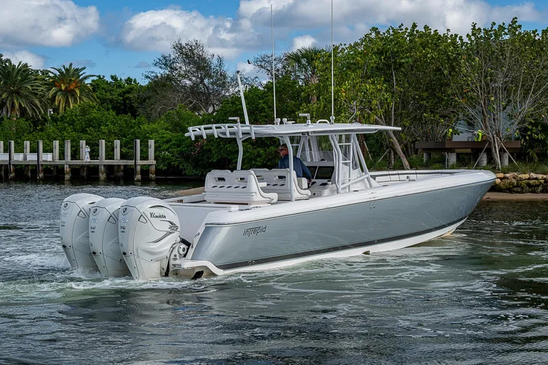 Slide: The Image of 2019 Intrepid 407 Nomad FE boat cruising on water with triple outboard engines. - 47