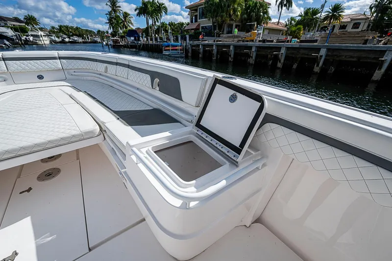 Slide: The Image of 2019 Intrepid 407 Nomad FE boat interior with seating and storage, dockside view. - 5