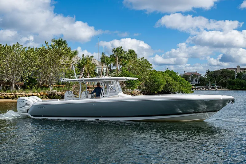 Slide: The Image of 2019 Intrepid 407 Nomad FE boat cruising on a scenic waterway with lush greenery. - 50