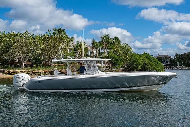 Slide: The Image of 2019 Intrepid 407 Nomad FE boat cruising on a sunny day near lush greenery. - 51