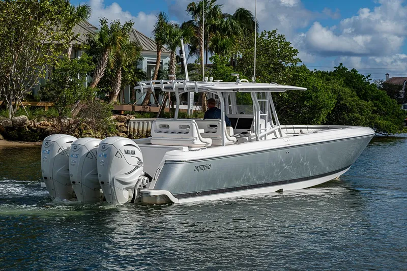 Slide: The Image of 2019 Intrepid 407 Nomad FE boat cruising on water with triple Yamaha engines. - 53