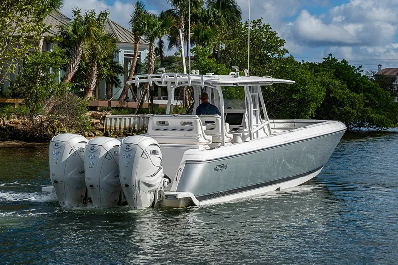 Slide: The Image of 2019 Intrepid 407 Nomad FE boat with triple Yamaha engines cruising on water. - 54