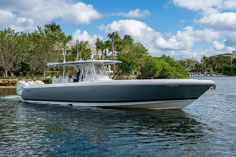 Slide: The Image of 2019 Intrepid 407 Nomad FE boat cruising on a scenic waterway with lush greenery. - 64