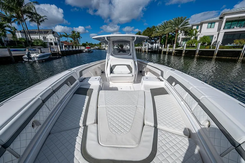 Slide: The Image of 2019 Intrepid 407 Nomad FE boat on a sunny waterfront, showcasing luxurious seating. - 9
