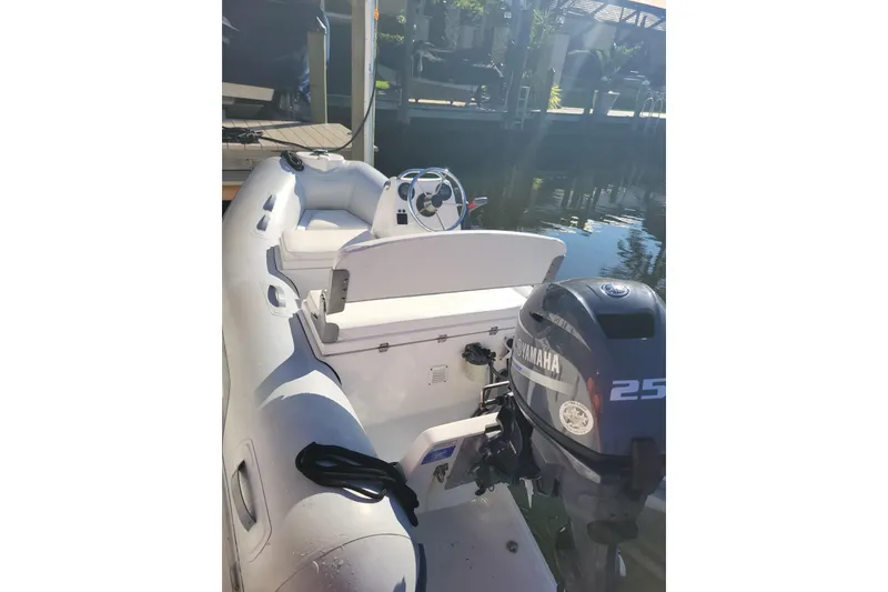 Slide: The Image of 2017 AB Inflatables Mares 10 VSX with Yamaha 25 outboard motor, docked on calm water. - 4