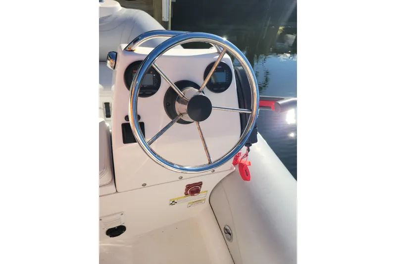 Slide: The Image of Steering wheel of 2017 AB Inflatables Mares 10 VSX boat, docked by water. - 6