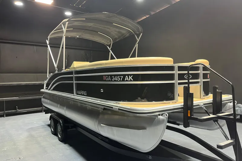 Slide: The Image of 2022 Harris Cruiser 230 pontoon boat in a showroom setting. - 1