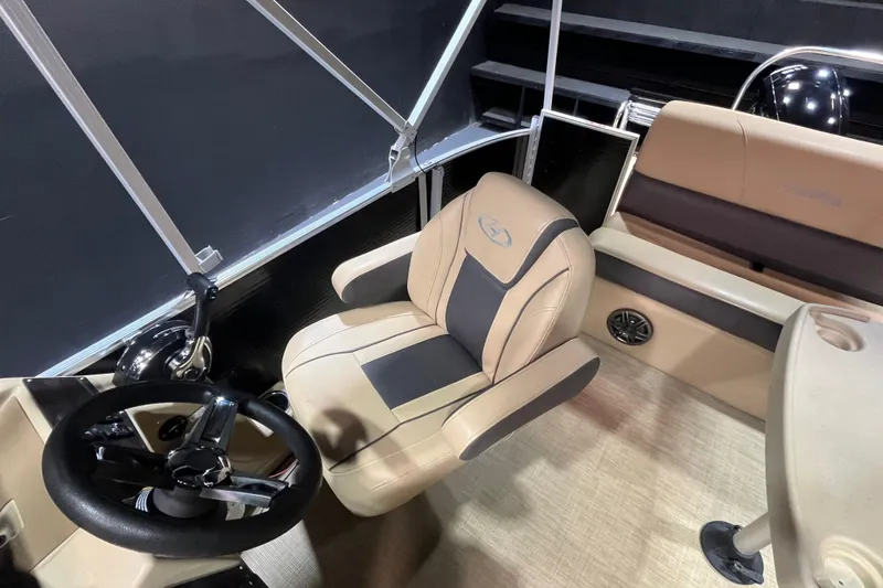 Slide: The Image of 2022 Harris Cruiser 230 boat interior with steering wheel and beige seating. - 10
