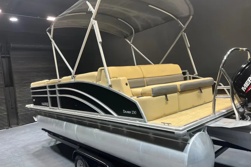 Slide: The Image of 2022 Harris Cruiser 230 pontoon boat with beige seating and canopy. - 3
