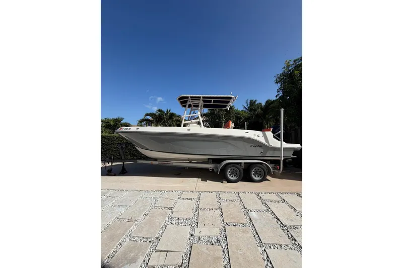 The Image of 2022 Trophy 2203 Center Console boat on trailer, parked outdoors under clear blue sky. - 1