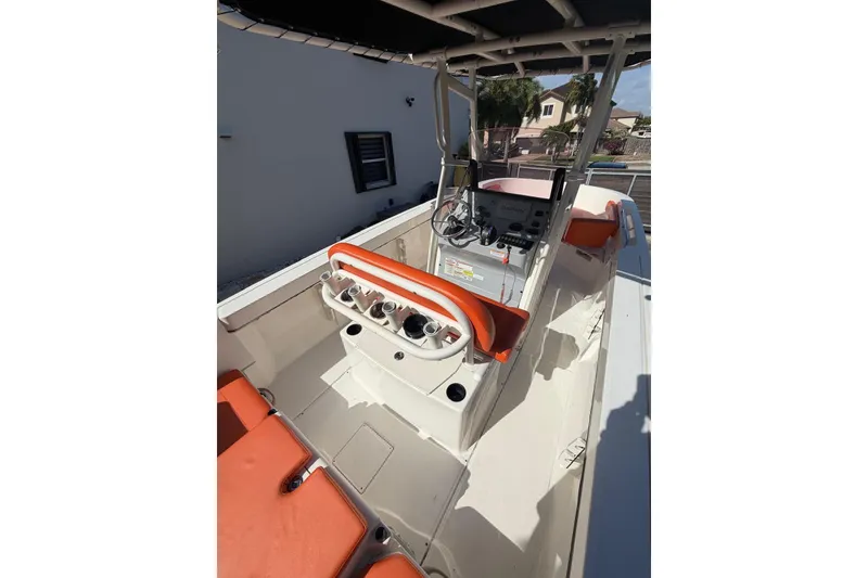 Slide: The Image of 2022 Trophy 2203 Center Console boat interior with orange seating and steering console. - 13
