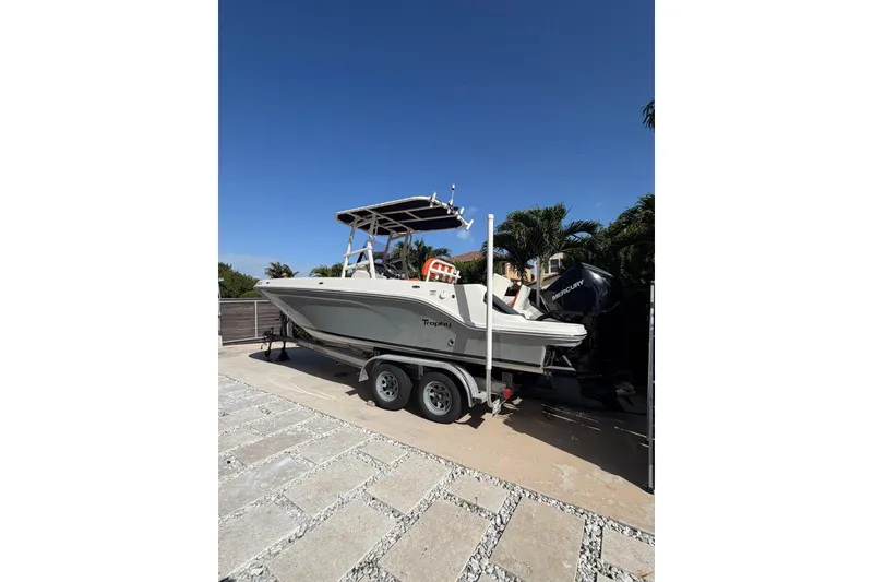 Slide: The Image of 2022 Trophy 2203 Center Console boat on trailer, parked outdoors under clear blue sky. - 3