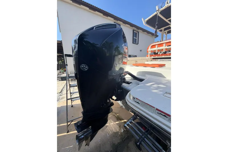 Slide: The Image of 2022 Trophy 2203 Center Console boat with powerful outboard motor, docked near a house. - 6