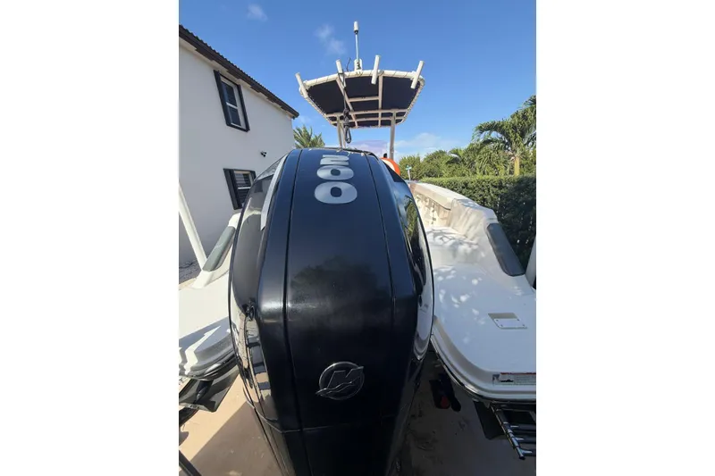 Slide: The Image of 2022 Trophy 2203 Center Console boat with powerful outboard motor, parked near a house. - 7