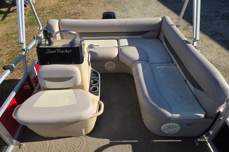 Slide: The Image of 2014 Sun Tracker Bass Buggy 16 DLX pontoon boat interior with beige seating and steering console. - 11