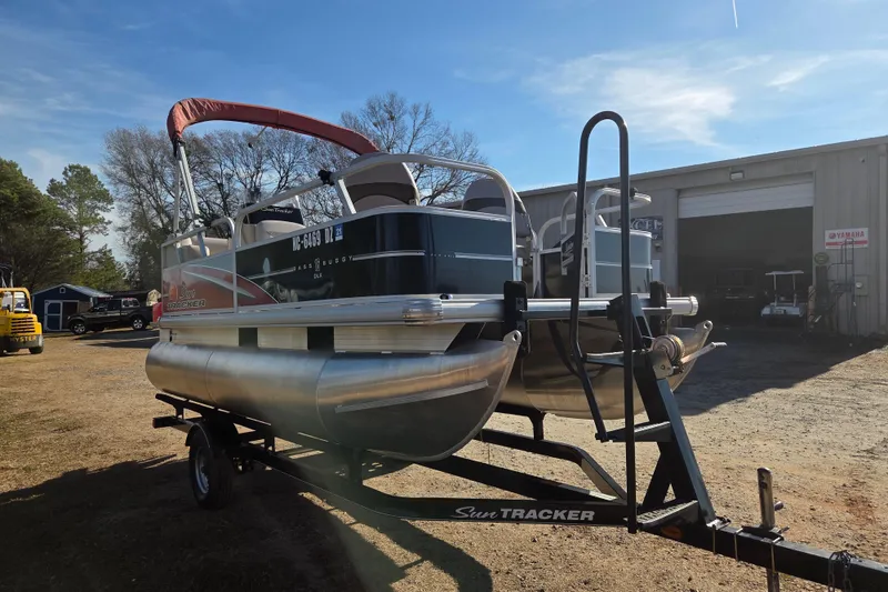 Slide: The Image of 2014 Sun Tracker Bass Buggy 16 DLX pontoon boat on trailer, outdoors. - 2