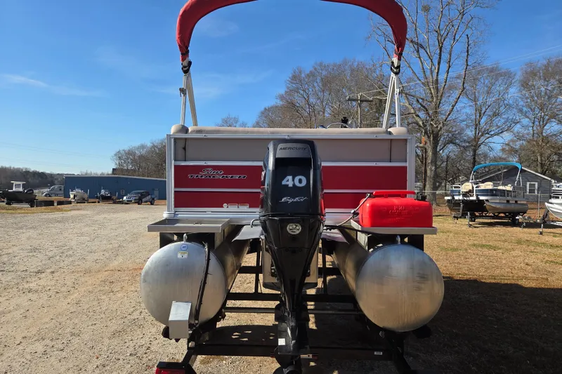 Slide: The Image of 2014 Sun Tracker Bass Buggy 16 DLX pontoon boat with Mercury 40 engine, parked outdoors. - 5