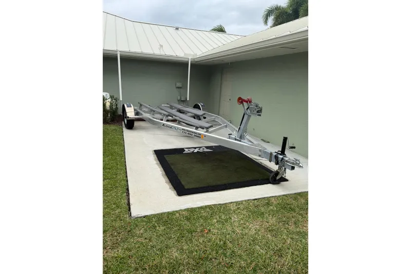 Slide: The Image of 2019 Key West 203 FS boat trailer parked on concrete driveway near a house. - 10