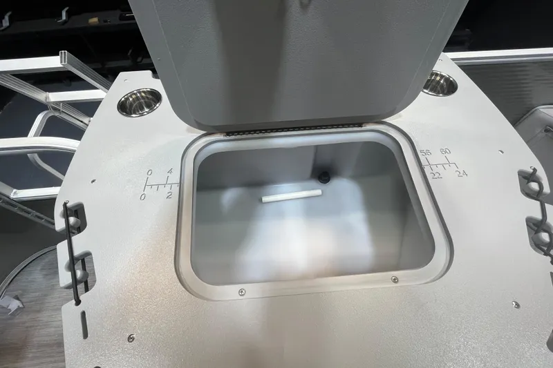 Slide: The Image of Open storage compartment on 2023 Bennington 22 FS boat, featuring measurement markings and cup holders. - 13