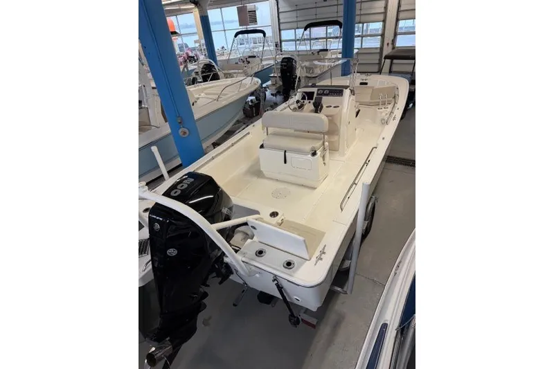 Slide: The Image of 2024 Boston Whaler 210 Montauk boat in showroom, featuring sleek design and powerful engine. - 15