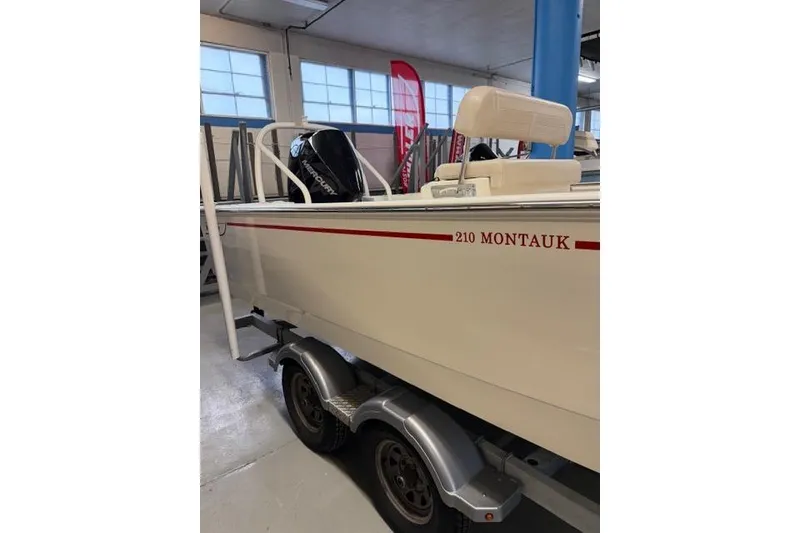 Slide: The Image of 2024 Boston Whaler 210 Montauk boat on trailer in indoor showroom. - 5