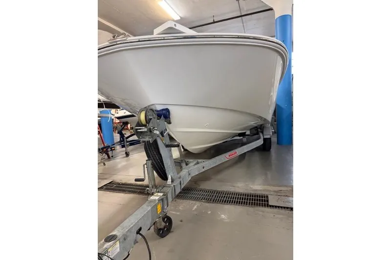 Slide: The Image of 2024 Boston Whaler 210 Montauk boat on trailer in indoor storage. - 7