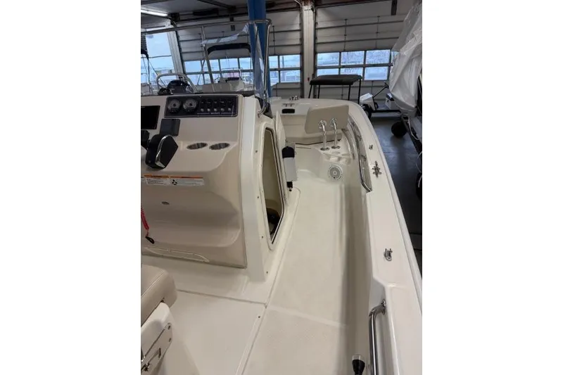 Slide: The Image of 2024 Boston Whaler 210 Montauk boat interior with console and seating in showroom. - 9