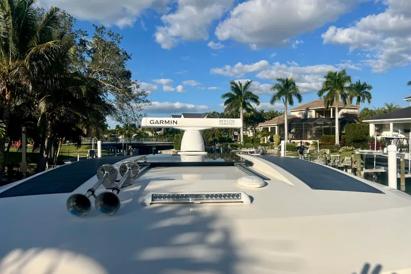 Slide: The Image of 2023 Scout 350 LXZ boat with Garmin radar, docked near palm trees and houses. - 11