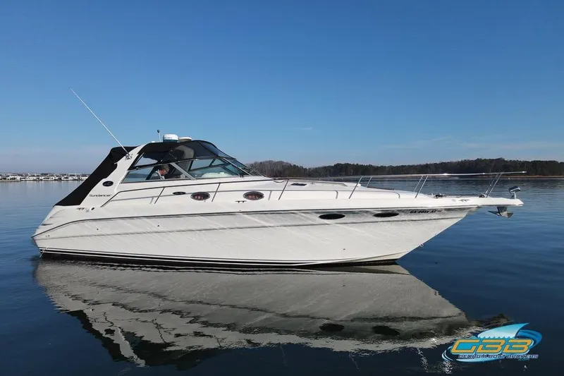 Slide: The Image of 1997 Sea Ray 330 Sundancer boat on calm water under clear blue sky. - 1