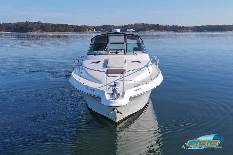 Slide: The Image of 1997 Sea Ray 330 Sundancer cruising on calm waters, front view. - 12