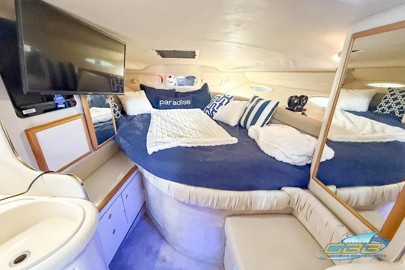 Slide: The Image of 1997 Sea Ray 330 Sundancer cabin with cozy bed, pillows, and TV. - 22