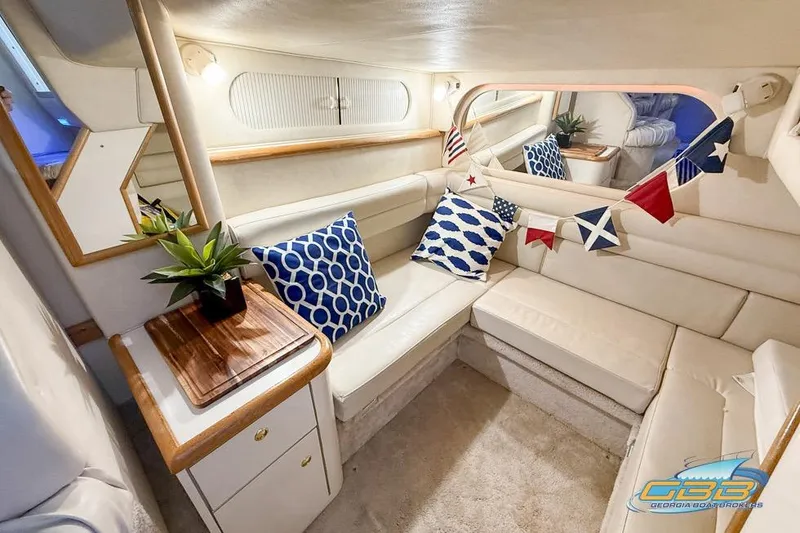 Slide: The Image of Interior of 1997 Sea Ray 330 Sundancer with cozy seating and nautical decor. - 25