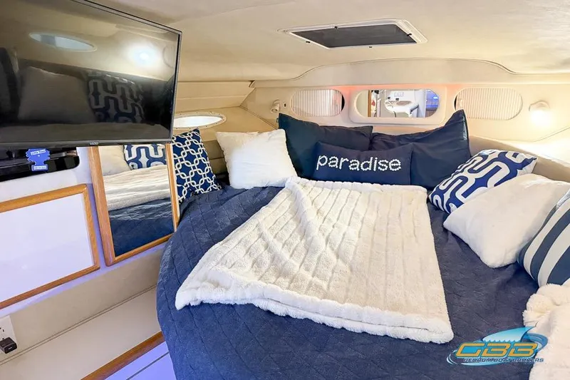 Slide: The Image of Cozy interior of 1997 Sea Ray 330 Sundancer with plush bedding and TV. - 31