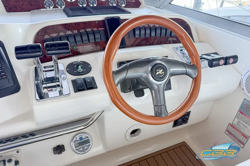 Slide: The Image of 1997 Sea Ray 330 Sundancer helm with wood-accented steering wheel and control panel. - 34