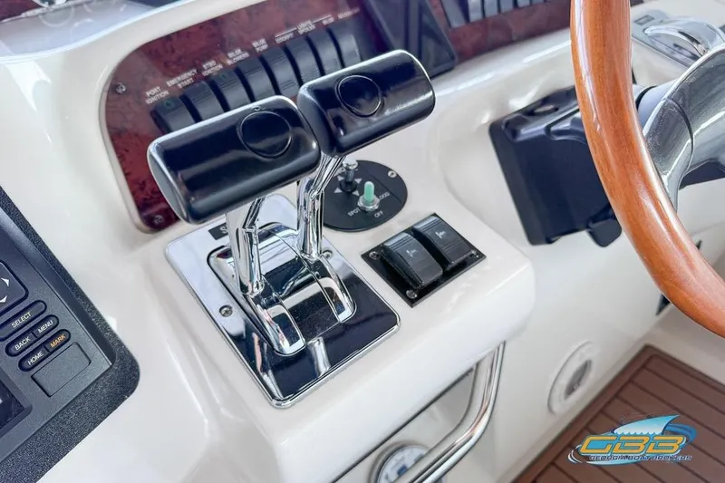 Slide: The Image of 1997 Sea Ray 330 Sundancer helm with throttle controls and wooden steering wheel. - 36