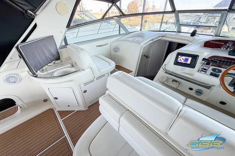 Slide: The Image of 1997 Sea Ray 330 Sundancer cockpit with white seating, wood accents, and navigation equipment. - 37
