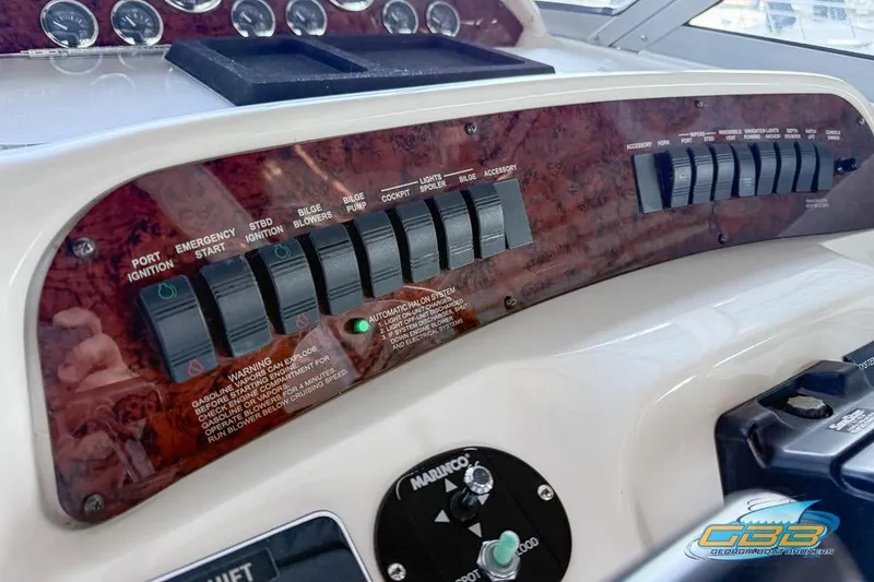 Slide: The Image of 1997 Sea Ray 330 Sundancer dashboard with control switches and warning labels. - 42