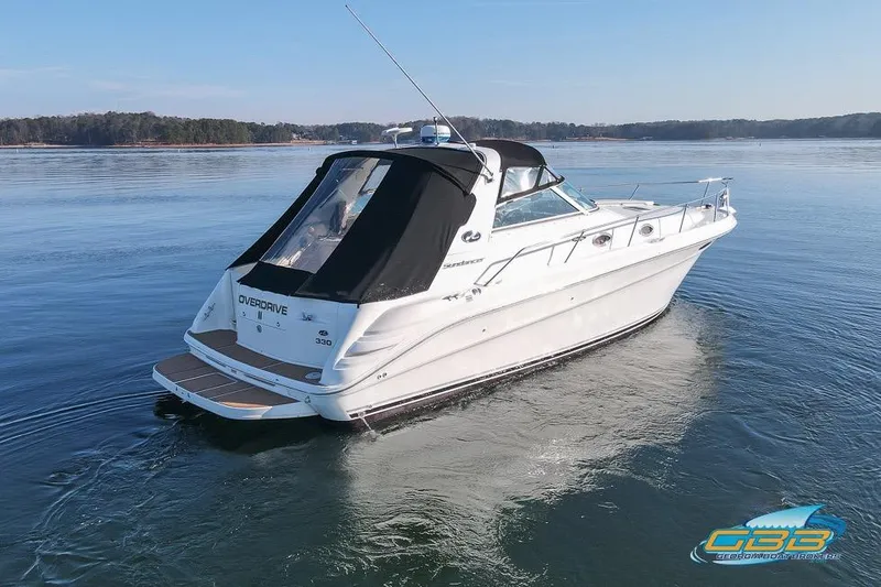 Slide: The Image of 1997 Sea Ray 330 Sundancer cruising on calm waters under clear skies. - 5