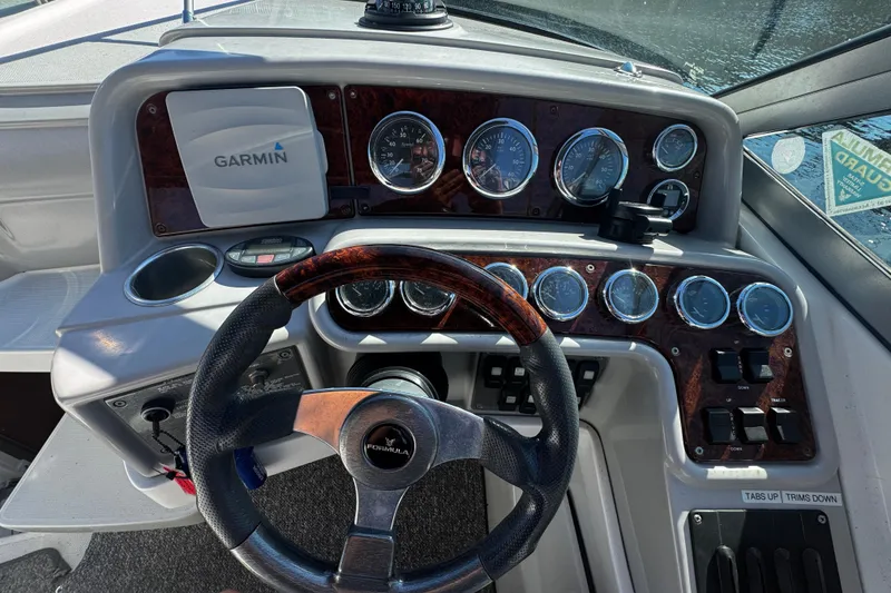 Slide: The Image of 2004 Formula 280 Sun Sport boat dashboard with Garmin navigation system and wood-trimmed steering wheel. - 9