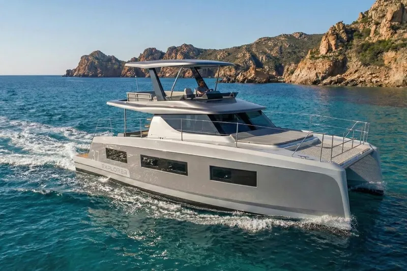 Slide: The Image of 2025 Aventura 37 Trawler cruising near rocky coastline in clear blue waters. - 5