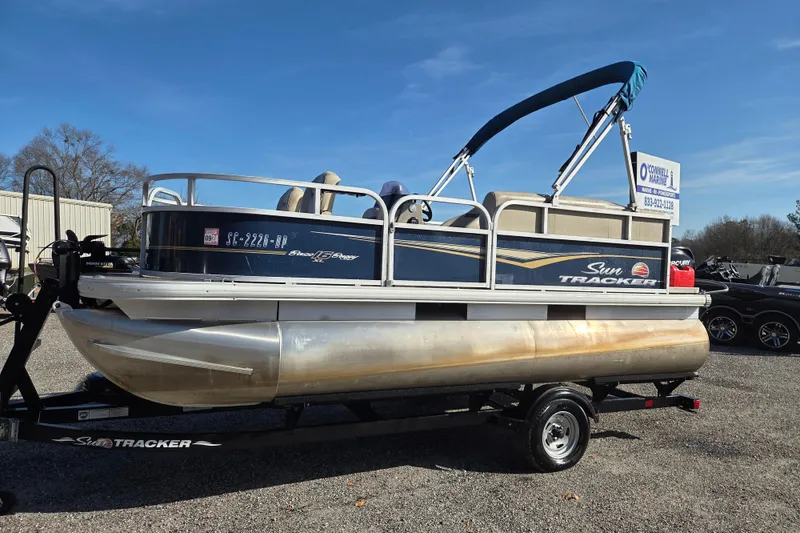 The Image of 2021 Sun Tracker Bass Buggy 16 XL pontoon boat on trailer, sunny day. - 0
