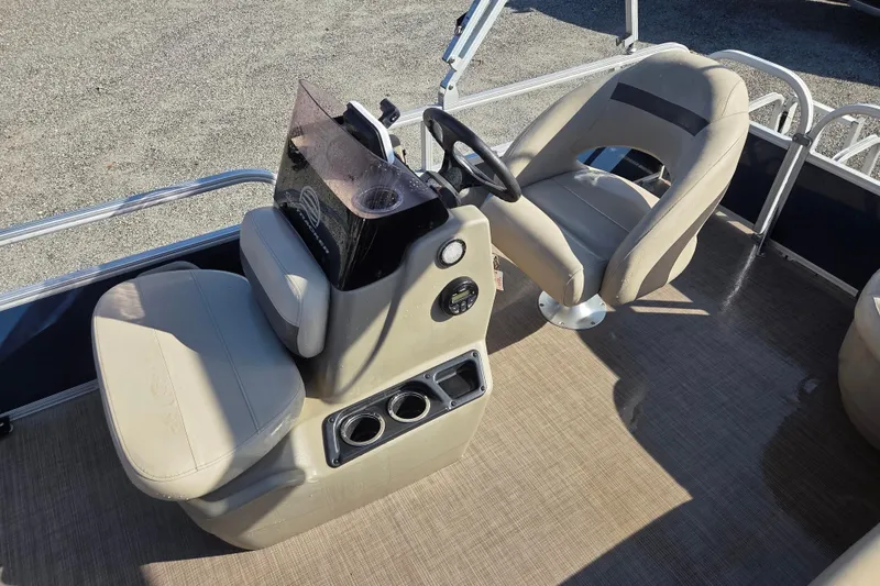 Slide: The Image of 2021 Sun Tracker Bass Buggy 16 XL interior with beige seating and steering console. - 13